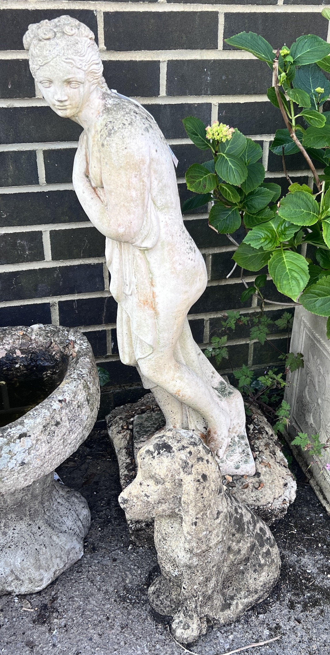 A reconstituted stone female bather garden ornament, height 78cm, together with a stone seated dog ornament